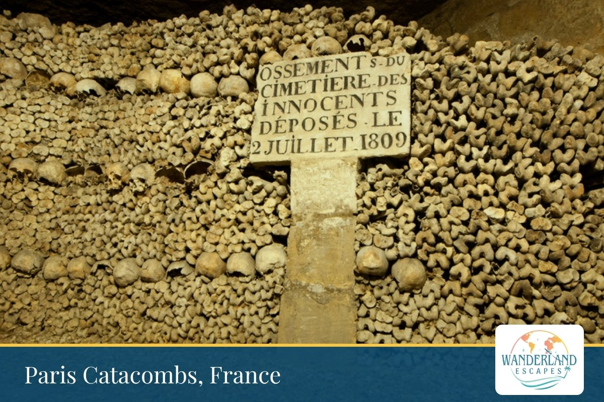 Stacked skulls and bones lining a wall in the Paris Catacombs